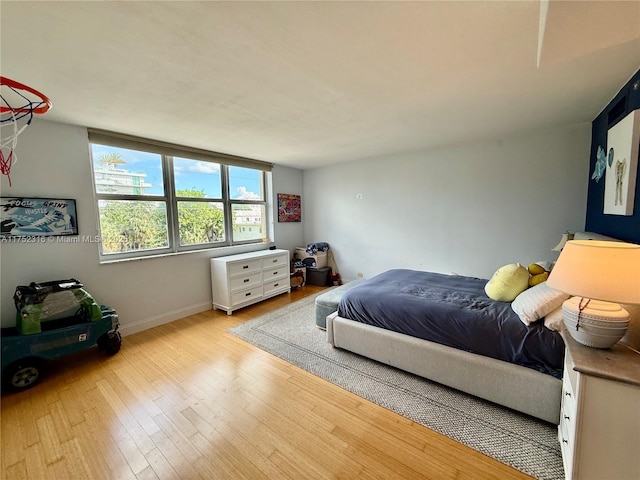 bedroom with wood finished floors and baseboards