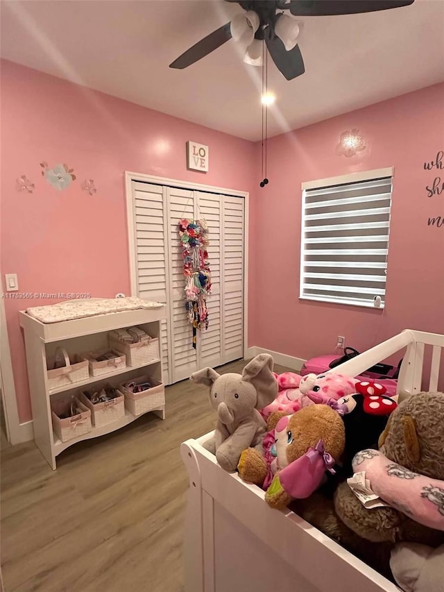 bedroom with ceiling fan, a closet, and wood finished floors