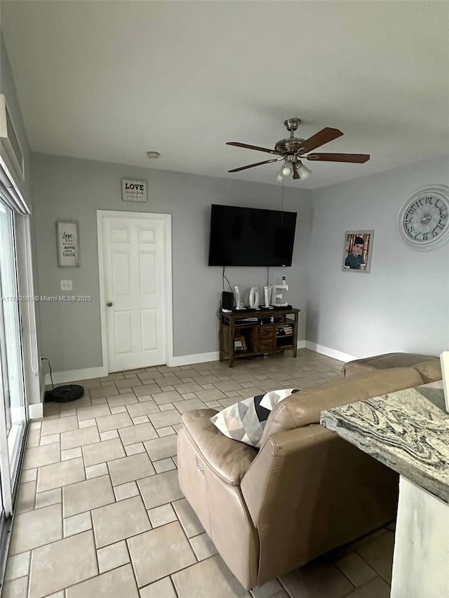 living area featuring ceiling fan and baseboards