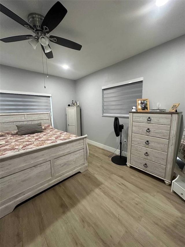 bedroom with baseboards, light wood-style flooring, and a ceiling fan