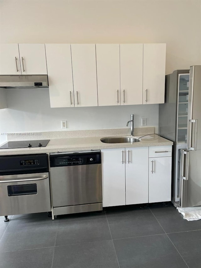 kitchen featuring stainless steel appliances, white cabinetry, a sink, and under cabinet range hood