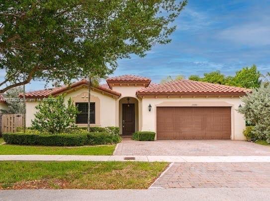 15340 SW 176th Ln, Miami, FL 33187 - mediterranean / spanish-style house with an attached garage, decorative driveway, stucco siding, and a tile roof