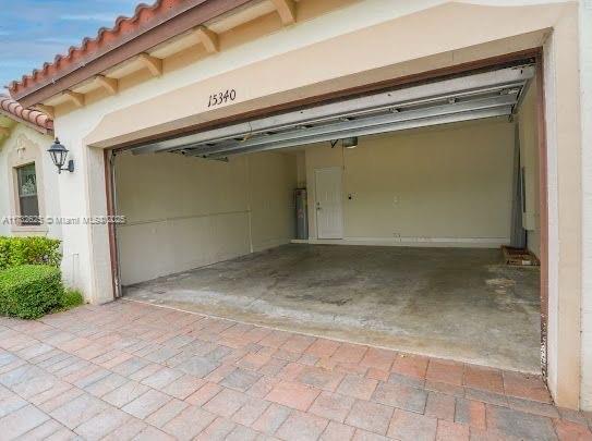 15340 SW 176th Ln, Miami, FL 33187 - garage with decorative driveway, water heater, and a garage door opener