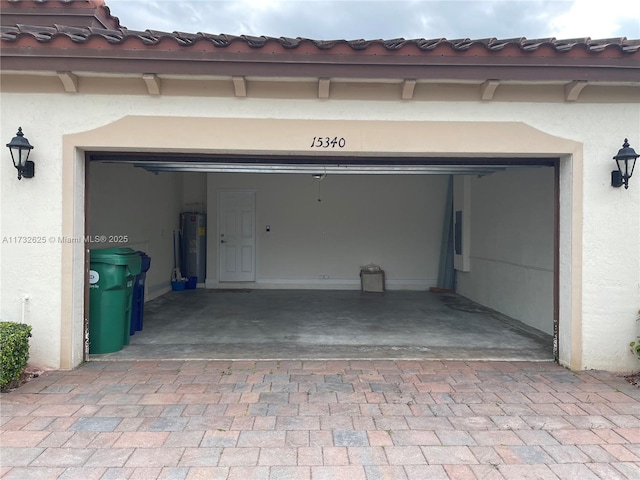 garage featuring decorative driveway and electric water heater