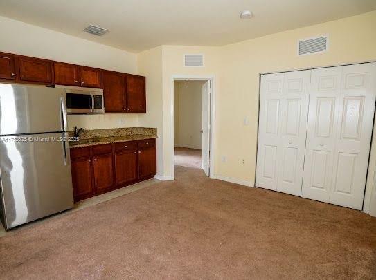 15340 SW 176th Ln, Miami, FL 33187 - kitchen with appliances with stainless steel finishes and light colored carpet