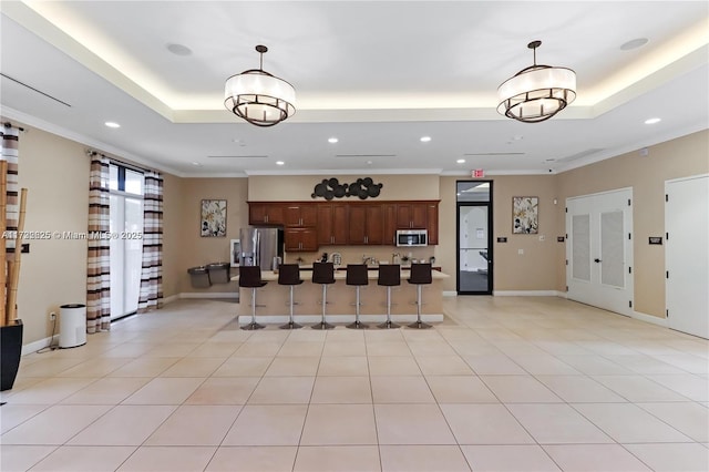 15340 SW 176th Ln, Miami, FL 33187 - kitchen with appliances with stainless steel finishes, a tray ceiling, recessed lighting, decorative light fixtures, and a breakfast bar