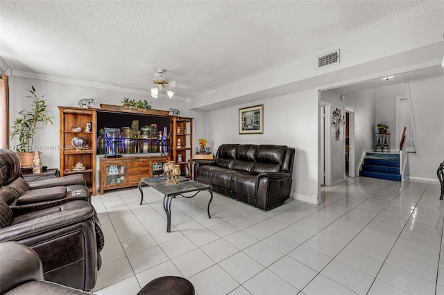 living area featuring baseboards, visible vents, light tile patterned flooring, stairs, and a textured ceiling