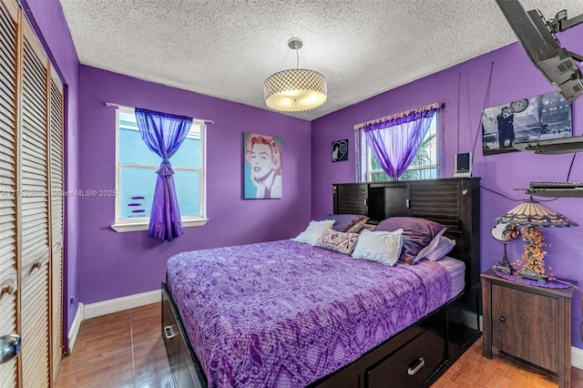 bedroom featuring a closet, baseboards, and a textured ceiling