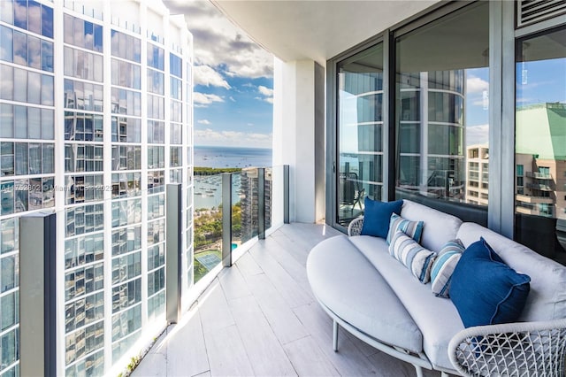 balcony with an outdoor hangout area and a water view