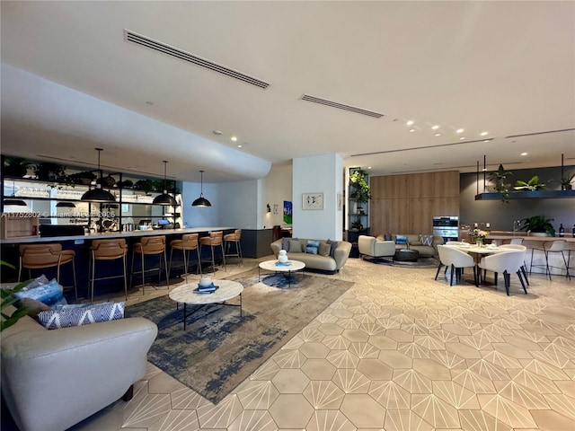 living area with visible vents, indoor wet bar, and recessed lighting