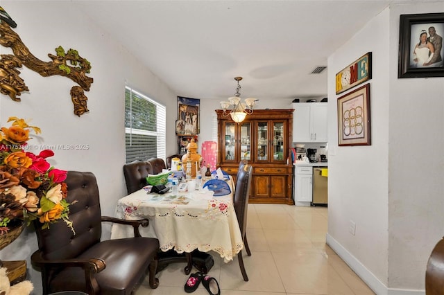 dining space with baseboards, light tile patterned flooring, visible vents, and an inviting chandelier