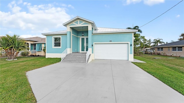 view of front facade with a garage, a standing seam roof, a front yard, and stucco siding