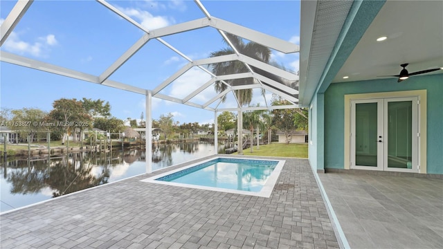 pool featuring a patio area, french doors, a water view, and a lanai