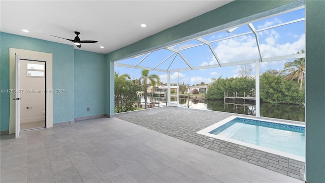 pool featuring a ceiling fan, a lanai, a water view, and a patio