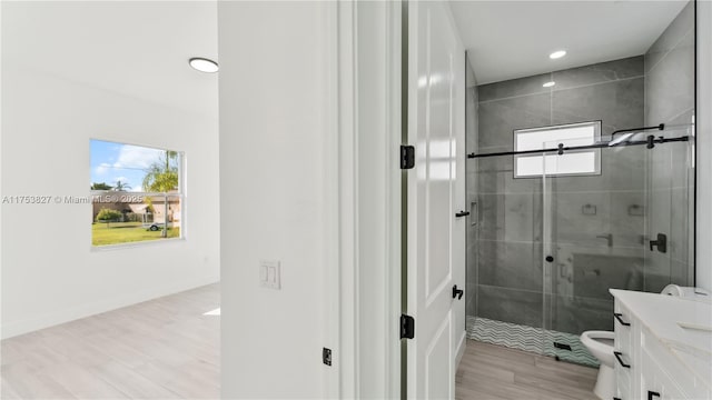 full bathroom featuring baseboards, toilet, wood finished floors, vanity, and a shower stall