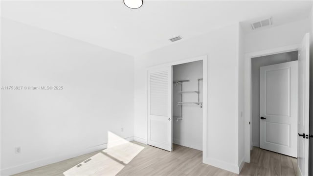 unfurnished bedroom with light wood-style flooring and visible vents