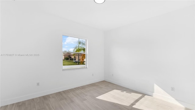 empty room with light wood finished floors and baseboards