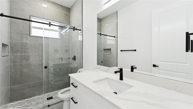 full bathroom featuring a stall shower, vanity, and toilet