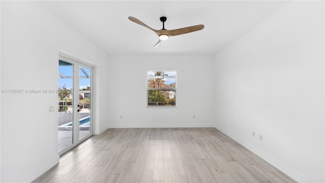 spare room with light wood-style floors, ceiling fan, and baseboards