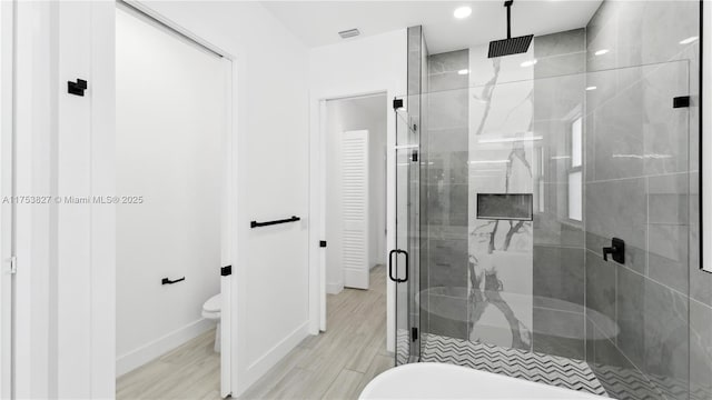 full bathroom with visible vents, baseboards, toilet, wood finished floors, and a shower stall