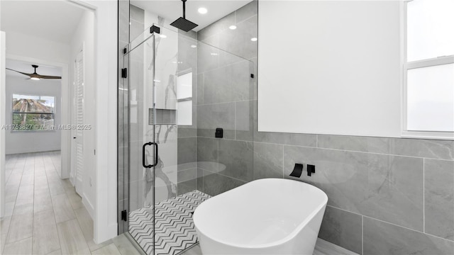 full bathroom featuring a stall shower, tile walls, and a soaking tub