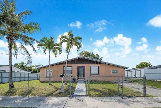 manufactured / mobile home with a fenced front yard, a gate, a front lawn, and stucco siding