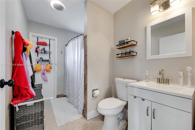 bathroom featuring a shower with shower curtain, toilet, vanity, baseboards, and speckled floor