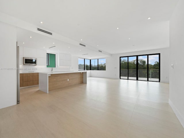 unfurnished living room featuring recessed lighting