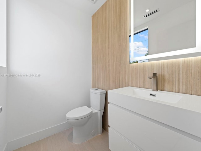 half bathroom featuring vanity and toilet