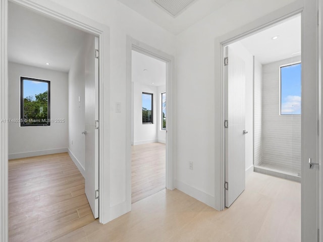 hallway featuring healthy amount of natural light, light wood-style flooring, and recessed lighting