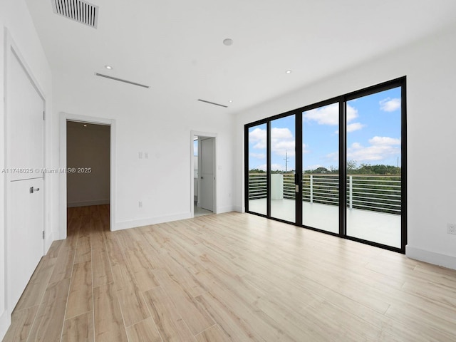 unfurnished room featuring light wood finished floors and baseboards
