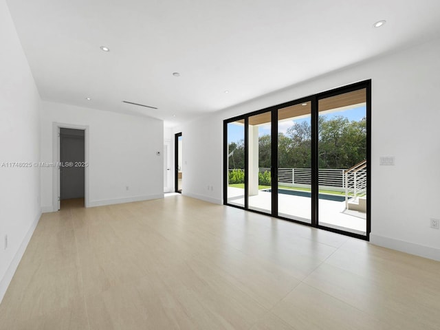 spare room featuring baseboards and recessed lighting