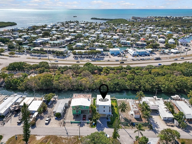 aerial view of property and surrounding area featuring a nearby body of water and nearby suburban area