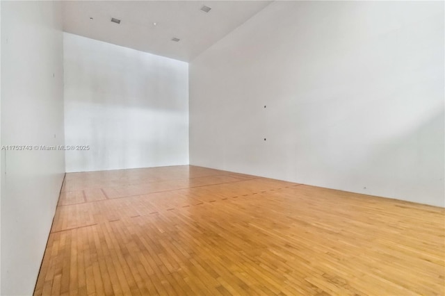 spare room with a sport court and wood-type flooring