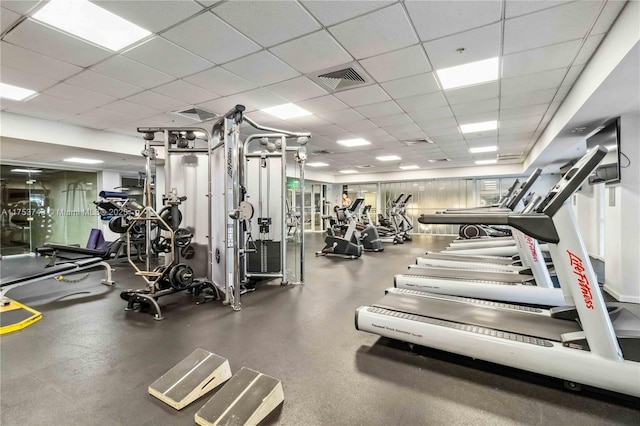 exercise room with a paneled ceiling and visible vents