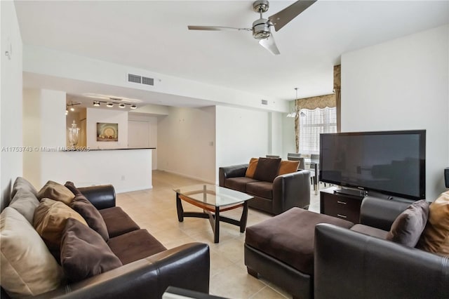 living area featuring light tile patterned floors, visible vents, baseboards, a ceiling fan, and track lighting