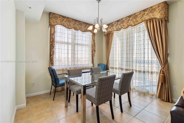 dining room featuring light tile patterned floors, baseboards, and an inviting chandelier
