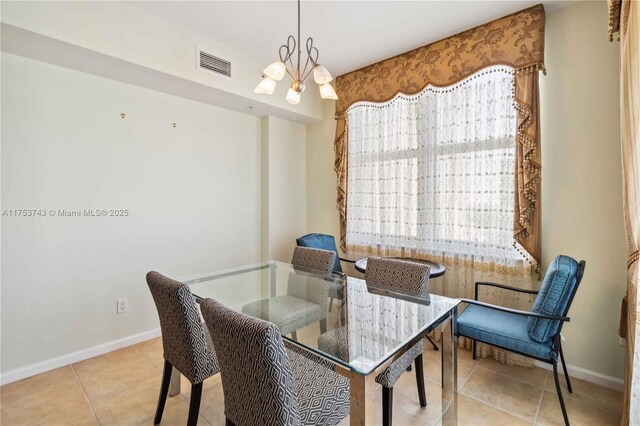 dining space featuring visible vents, baseboards, a notable chandelier, and tile patterned flooring