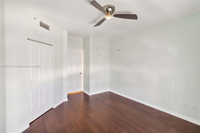 empty room with visible vents, baseboards, a ceiling fan, and wood finished floors