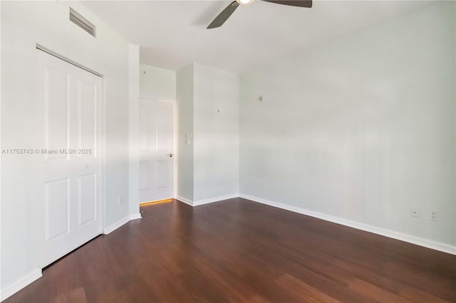 empty room featuring ceiling fan, wood finished floors, visible vents, and baseboards