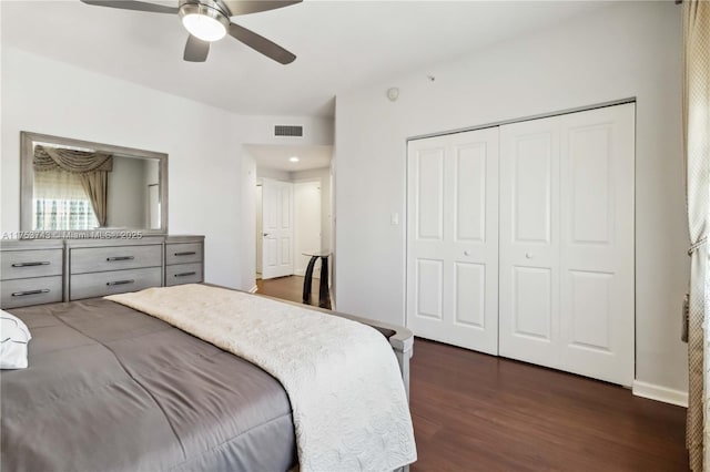 bedroom with a closet, dark wood-style flooring, visible vents, and a ceiling fan