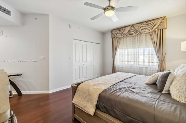 bedroom with baseboards, visible vents, dark wood-style floors, ceiling fan, and a closet