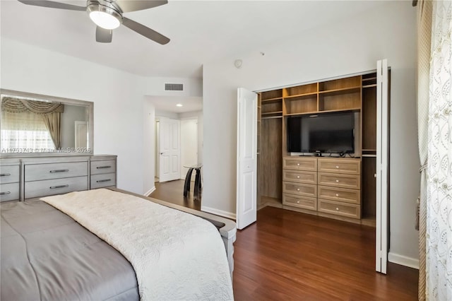 bedroom with dark wood-style floors, a closet, visible vents, ceiling fan, and baseboards