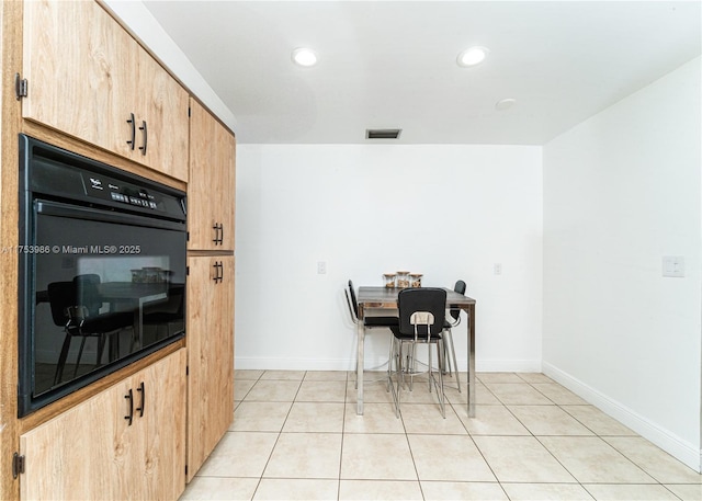 kitchen featuring light tile patterned floors, visible vents, oven, and baseboards