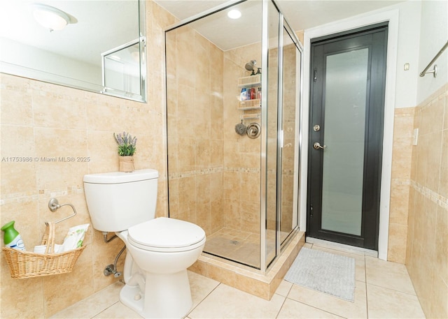 full bathroom featuring toilet, a shower stall, tile walls, and tile patterned floors