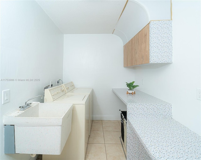 laundry room with light tile patterned floors, independent washer and dryer, a sink, and baseboards