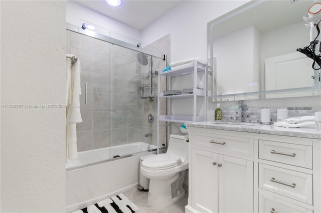 full bath featuring toilet, tile patterned floors, combined bath / shower with glass door, and vanity