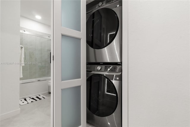 laundry area with laundry area, stacked washing maching and dryer, and tile patterned flooring