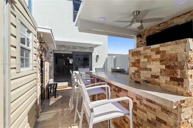 view of patio / terrace with outdoor wet bar and a ceiling fan