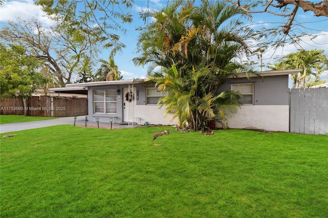 view of front of property featuring a front yard, fence, and brick siding